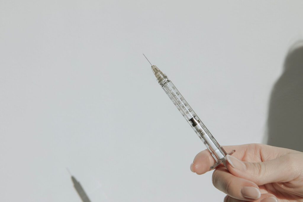 An image of a woman holding a needle for injection.