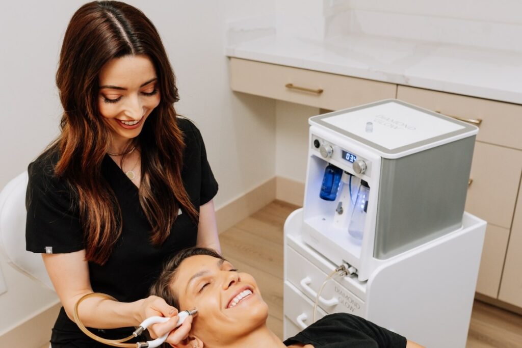 Smiling woman getting a facial by a smiling skin care professional.