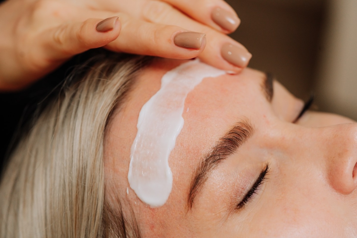 Woman relaxing while getting facial at a medspa.