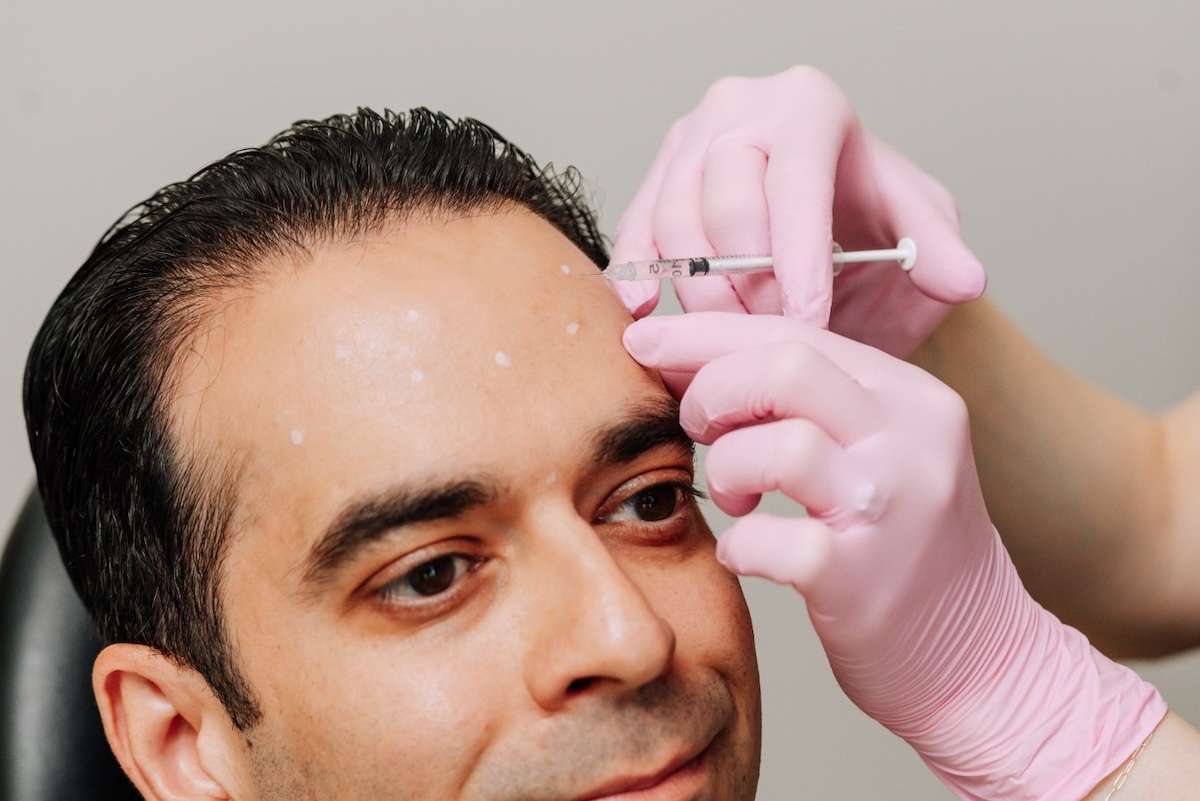 Man receiving Botox injections to forehead