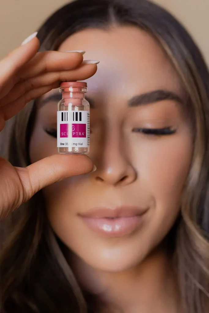 woman holding up sculptra bottle to compare the difference between sculptra and radiesse