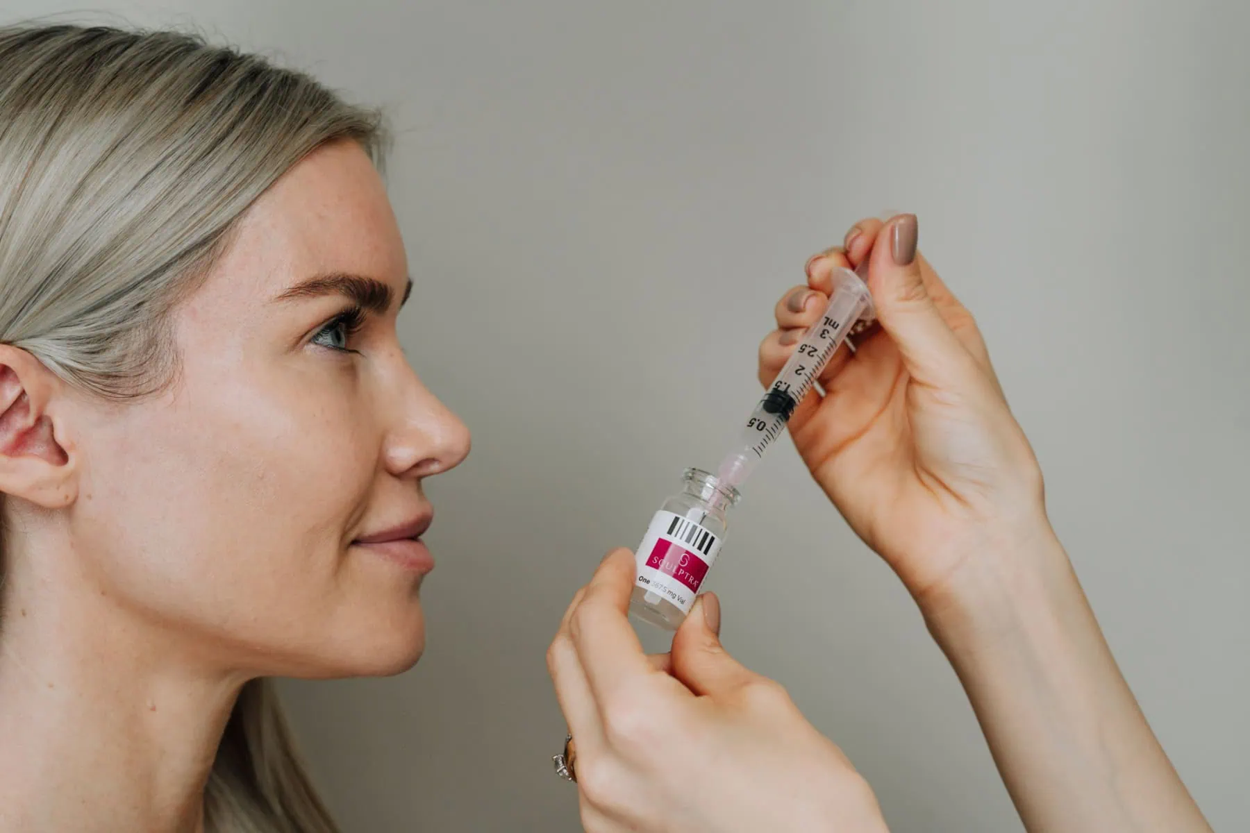 smiling woman about to receive a Sculptra injection