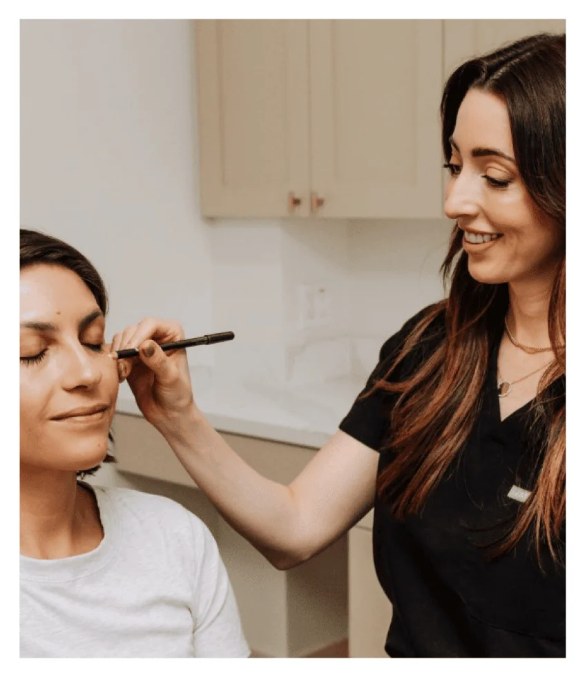 Botox injector Katie marking injection spots on a woman's face