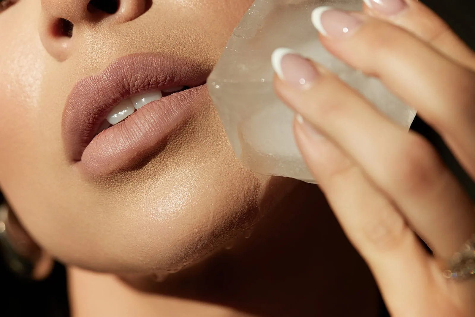 Woman cooling facial skin with ice cube to soothe heat-related melasma